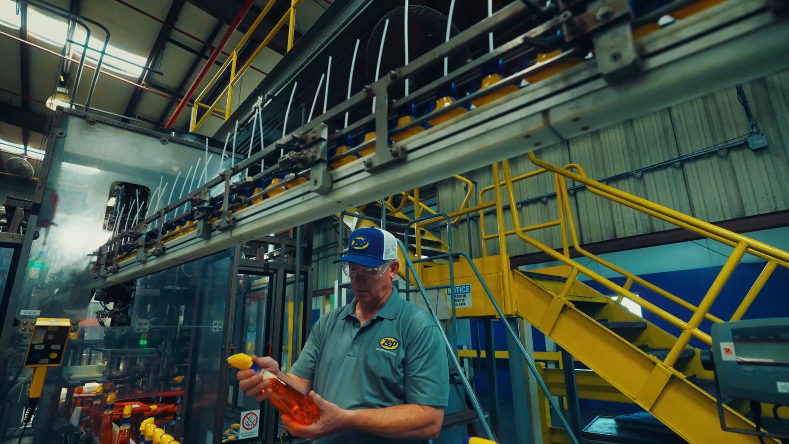 Zep worker on the production floor holding a product